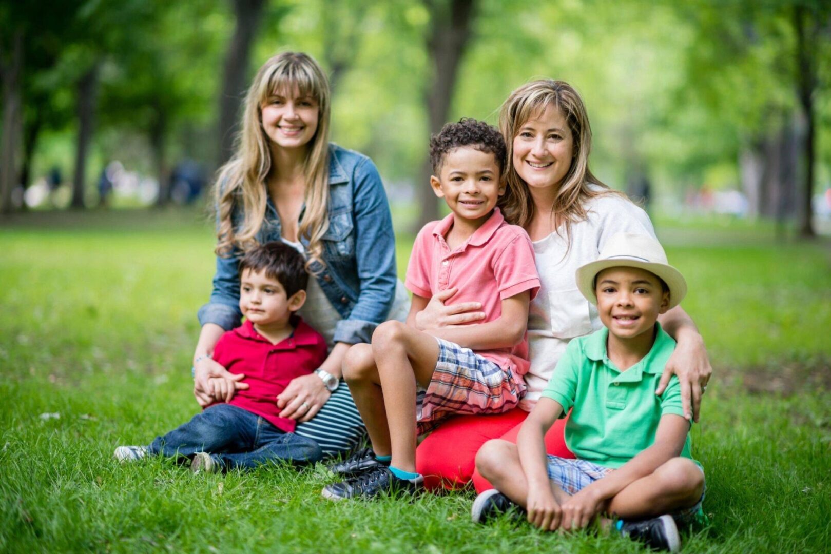 A group of people sitting on the grass.